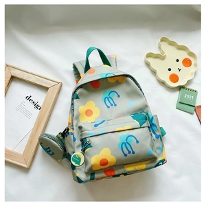Detail of floral kids backpack with matching coin purse and green cartoon charm