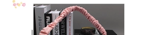 Detail view of the soft pink pleated fabric texture on a stylish scrunchie headband