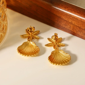 Macro detail of golden starfish and shell pendant earrings with high-polish metallic texture