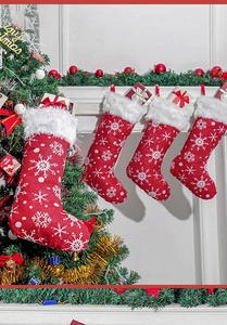 Detailed view of four red and white embroidered snowflake Christmas stockings on a fireplace