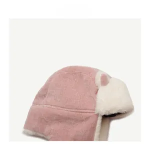 Detail of pink corduroy fabric and soft white plush fur on winter trapper hat