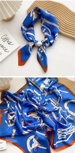 Detail of royal blue satin square scarf featuring vintage horse harness print and orange border