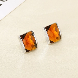 Detail of amber rectangular faceted glass earrings with 18K gold plated textured edges