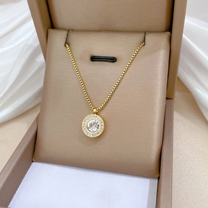 Detail of a gold titanium necklace with a sparkling crystal pendant in a gift box