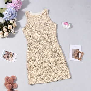 Robe à paillettes dorée sans manches présentée avec des fleurs et des accessoires vintage