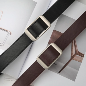Detailed texture of black and brown leather belts with matte silver rectangular buckles