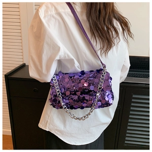 Close-up of purple sequin handbag with silver chain strap and leather shoulder strap