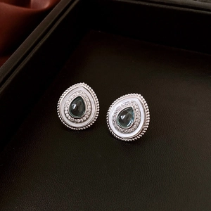 Detail of silver teardrop earrings with cyan pear-shaped stone and zircon pavé inlay