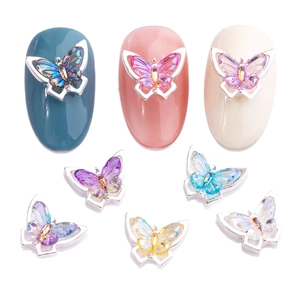 3D butterfly nail charms in gradient colors on different manicured nail tips