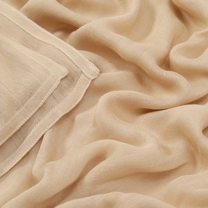 Detalle de tela modal beige claro con textura fina y costuras reforzadas en el borde