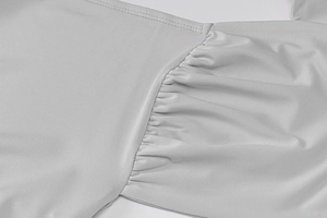Détail de la texture en maille gris clair et de la finition raffinée des coutures plissées
