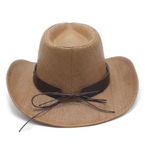 Detail of brown woven straw cowboy hat with dark leather band and western-style brim