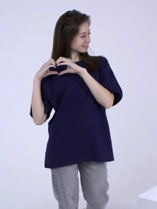 Λεπτομέρεια από βαθύ μπλε oversized βαμβακερό t-shirt συνδυασμένο με γκρι τζιν παντελόνι