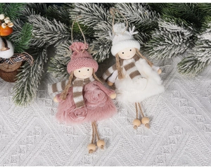 Detail of plush Christmas angel dolls with knit hats and silver antlers on lace fabric