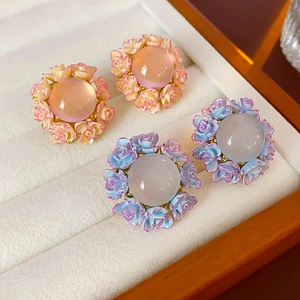 Detail of floral stud earrings with translucent stones and resin roses in jewelry box