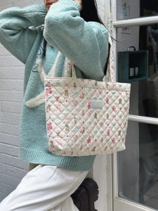 Detailed view of quilted cotton tote bag featuring cute cartoon bear and bow patterns