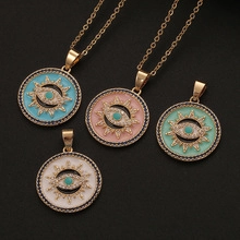 Macro shot of colorful evil eye pendants with gold plating and enamel inlay on black surface