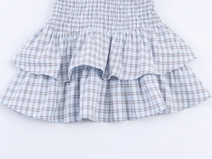 Detail of light blue plaid dress with elastic pleated waist and double-layer ruffled hem