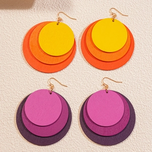 Geometric wooden drop earrings with orange and purple gradient round charms on beige background