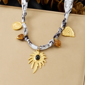 Leopard print silk ribbon necklace with gold palm leaf and heart charms on beige background