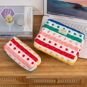 Quilted cotton striped polka dot cosmetic bags set on desk with laptop and books