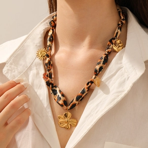 Detailed shot of leopard print fabric cord necklace with golden sun and flower charms