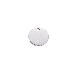 Macro shot of mirror-polished stainless steel round pendant with detailed flower engraving
