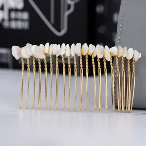 Dettaglio macro del pettine per capelli dorato a mano con pietre naturali bianche