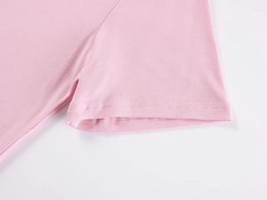 Close-up detail of double-stitched sleeve cuff on soft pink cotton knit T-shirt