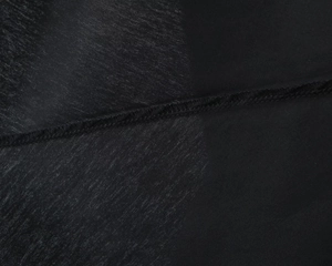 Macro shot showing the smooth fabric texture and precise stitching on the black dress