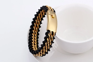 Close-up of black braided leather strap with a gold magnetic metal clasp on a white cup
