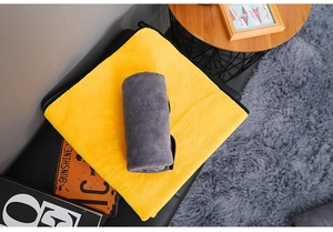 Detail of coral fleece pet towels in yellow and grey showing soft texture on tray