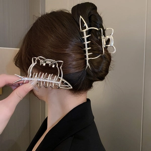 Détail de la pince à cheveux arête de poisson argentée avec strass sur un chignon