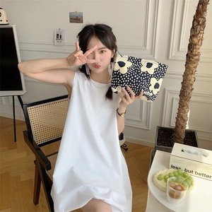 Floral print cotton makeup bag held by a model in a minimalist interior scene