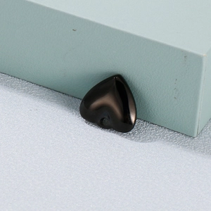 Pendentif coeur noir poli en acier titane sur un fond clair à texture fine