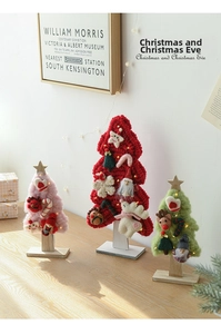 Close-up of handmade wool felt Christmas tree with LED lights and wooden base decor