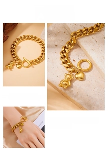 Detail of gold-plated stainless steel chain bracelet with bear and heart charms and OT clasp