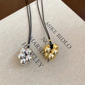 Collana con pendente a grappolo di sfere geometriche in finitura oro e argento