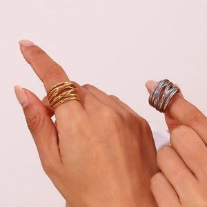 Detail of intertwined woven rings in 18K gold and silver finishes on a model's fingers