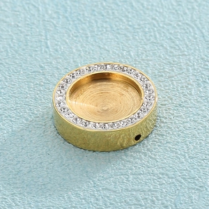 Détail macro du support pendentif en acier titane doré avec sertissage en micro-zircon