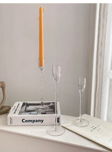 Detail view of tulip shaped glass candle holders in three sizes on books