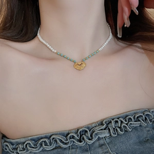 Detailed macro view of Chinese ruyi emerald lock pendant and elegant pearl necklace