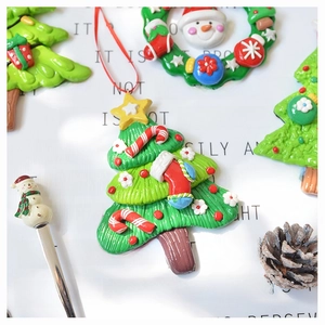Macro detail of 3D polymer clay Christmas tree and wreath ornaments with festive textures
