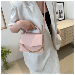 Pink crossbody bag with crocodile embossed leather texture and gold chain detail