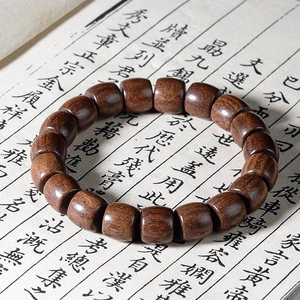 Bracelet ethnique en bois de santal vert à perles baril sur un vieux livre vintage