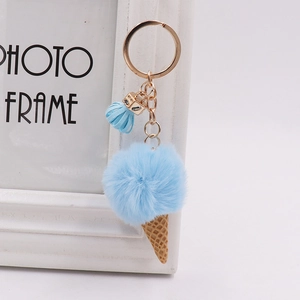 Detail of blue plush ice cream keychain with waffle cone, gold ring, and leather tassel
