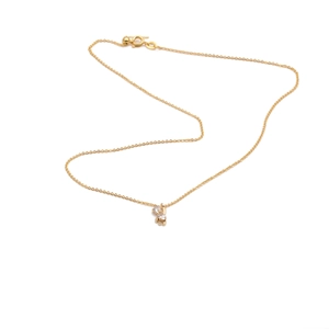 Close-up of gold plated bear pendant with two small gems on a fine chain necklace