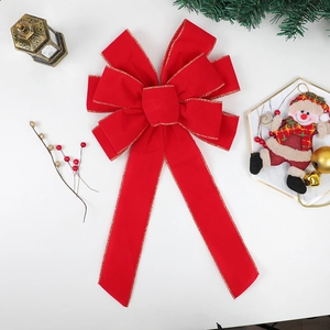 Large red velvet Christmas bow with gold trim on a festive white holiday background