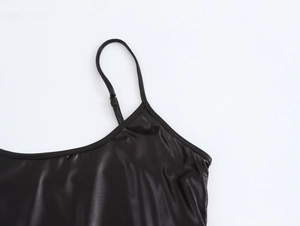 Detailed close-up of smooth black satin fabric and adjustable shoulder straps of the dress