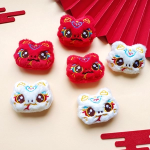 Detail of plush lion dance heads in red and white with festive Chinese embroidery